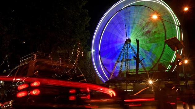 Vehicles drive past a ferris wheel at Bandra Fair in Mumbai on Tuesday. (Shashi S Kashyap / HT PHOTO) Vehicles drive past a ferris wheel at Bandra Fair in Mumbai on Tuesday. (Shashi S Kashyap / HT PHOTO)