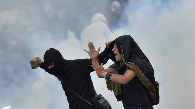 A protester (L) holds a cobblestone during clashes with police within a protest called by several French unions against the labour law reform, on September 12, 2017 in Nantes, western France. (Loic Venance / AFP) A protester (L) holds a cobblestone during clashes with police within a protest called by several French unions against the labour law reform, on September 12, 2017 in Nantes, western France. (Loic Venance / AFP)