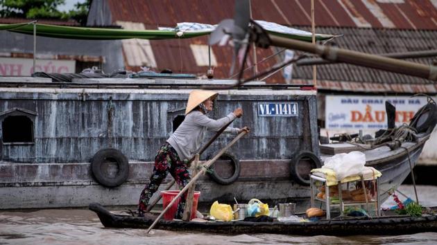 A woman who makes a living by selling bread and other food and drinks from her boat, rows in search of customers in a canal off the Song Hau river at the floating Cai Rang market in Can Tho, a small city in the Mekong Delta.(Roberto Schmidt/AFP)