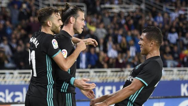 Real Madrid players celebrate with Gareth Bale (C) after the Welshman scored a goal during their 3-1 win over Real Sociedad at the Anoeta Stadium in San Sebastian on Sunday. (AFP) Real Madrid players celebrate with Gareth Bale (C) after the Welshman scored a goal during their 3-1 win over Real Sociedad at the Anoeta Stadium in San Sebastian on Sunday. (AFP)