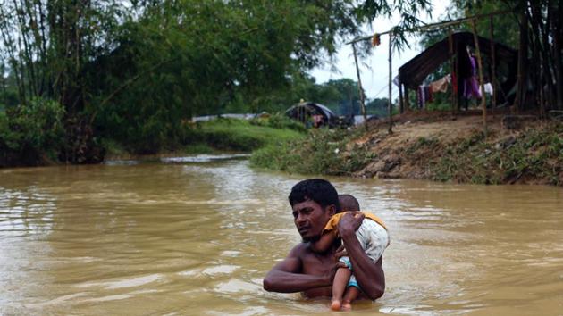 A Rohingya refugee carries a baby through a swollen stream in Cox's Bazar, Bangladesh, on September 18, 2017. (Reuters) A Rohingya refugee carries a baby through a swollen stream in Cox's Bazar, Bangladesh, on September 18, 2017. (Reuters)