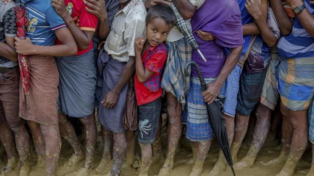 A young Rohingya Muslim boy, who crossed over from Myanmar into Bangladesh, waits along with others for his turn to collect food aid near Kutupalong refugee camp, Bangladesh, Tuesday.(AP Photo)