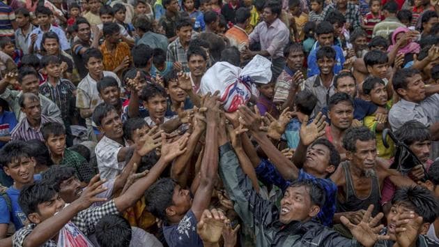 Rohingya Muslims stretch their arms out to collect food near Balukhali refugee camp, Bangladesh. Officials in the Northeast fear many refugees would try and infiltrate Assam. (AP Photo/Dar Yasin)(AP)