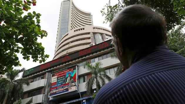 A man looks at a screen across a road displaying the Sensex on the facade of the Bombay Stock Exchange (BSE) building in Mumbai. (Reuters File Photo) A man looks at a screen across a road displaying the Sensex on the facade of the Bombay Stock Exchange (BSE) building in Mumbai. (Reuters File Photo)