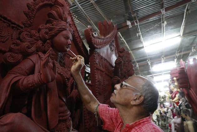 Shukharajan Pal works on one of his Durga idols at Khadki Kumartuli in Pune on Monday.(Rahul Raut/HT PHOTO)