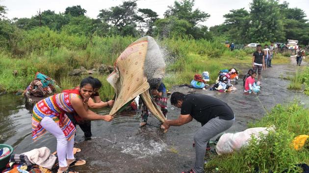 People wash clothes and bed sheets at Khadakwasla dam in Pune on Sunday, September 17. (Pratham Gokhale/HT PHOTO) 
