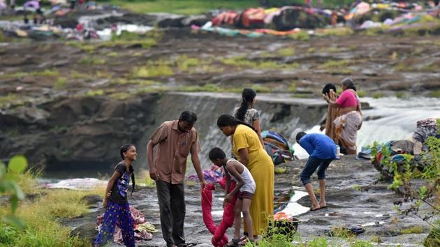 A family washes bed sheets at Khadakwasla dam in Pune. This mass cleaning happens just before the start of the Navratri festival. (Pratham Gokhale/HT PHOTO) 