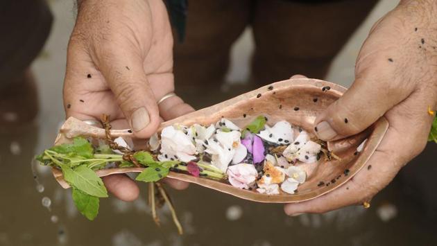 There are various postures that accompany the practice of ‘Tarpan,’ namely for the Devas (Gods), Rishis (Sages) and Pitrus (ancestors). For the departed ancestors, the offering is made to flow over the right side of the right palm and the thumb of the right hand. (Samir Jana/HT PHOTO) 