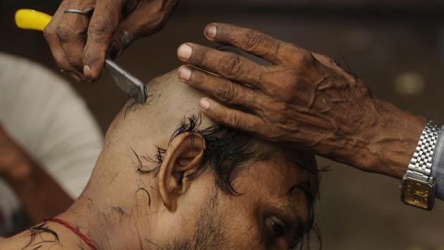 A man gets his head shaved in order as part of a Hindu ritual, which demands this of men who lose their fathers. The performance of ‘Shraadh’ by a son during Pitru Paksh is compulsory in Hinduism in order to make sure that the soul of the ancestor finds peace in heaven. (Samir Jana/HT PHOTO) 