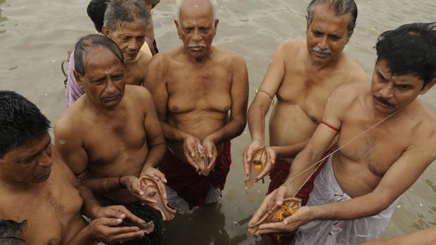 Men offer food and water to their departed ancestors on the banks of the river Hooghly at Jagannath Ghat in Kolkata. (Samir Jana/HT PHOTO) 