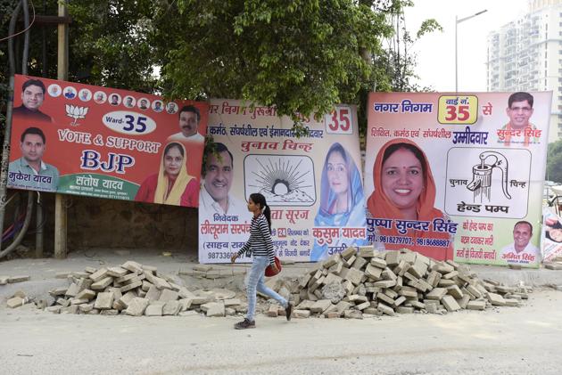 A girl walks past hoardings of MCG poll candidates on Tuesday. (Sanjeev Verma/HT PHOTO) A girl walks past hoardings of MCG poll candidates on Tuesday. (Sanjeev Verma/HT PHOTO)