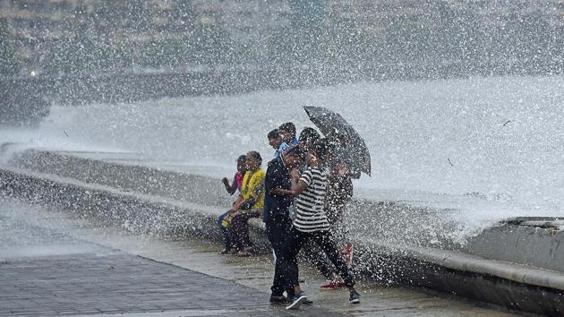 People enjoy the high tide at Marine Drive. (Pratik Chorge/HT Photo)