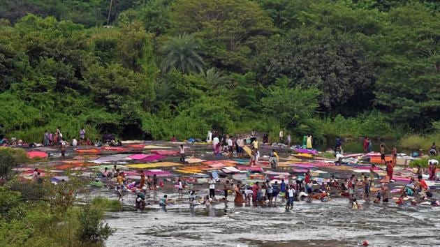 People wash clothes and bed sheets at Khadakwasla dam in Pune on Sunday. (Pratham Gokhale/HT PHOTO) 