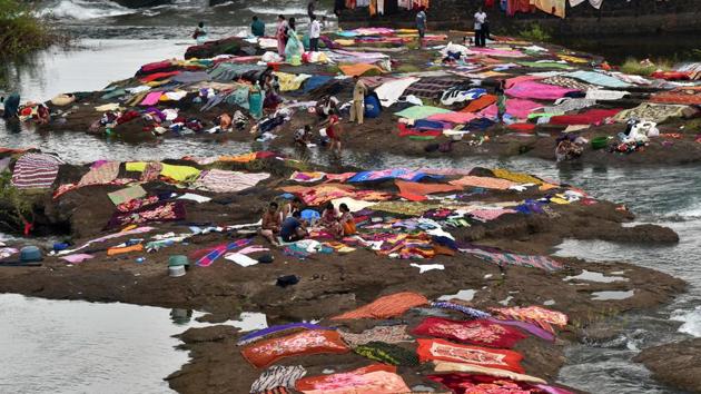 People wash clothes and bed sheets at Khadakwasla dam in Pune on Sunday.  (Pratham Gokhale/HT PHOTO) 