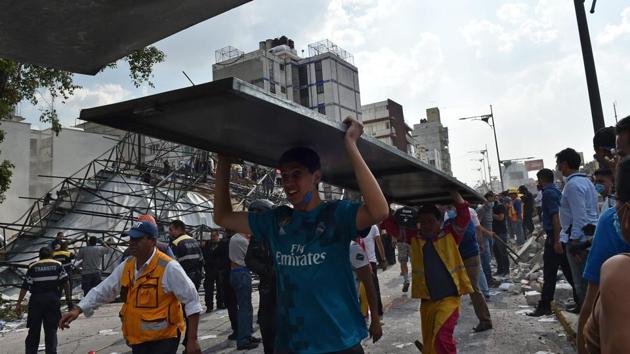 Volunteers wearing dust masks wait in line to pass out rubble as rescue workers search inside a collapsed building in the Condesa neighborhood of Mexico City. On Twitter, relatives posted pleas for news of family members. At least one survivor was pulled from a collapsed building in Condesa and another rescued from a six-story apartment building nearby. Millions fled into the streets, where they weathered the violent shaking and desperately sought word about the welfare of family and friends. (Rebecca Blackwell / AP) Volunteers wearing dust masks wait in line to pass out rubble as rescue workers search inside a collapsed building in the Condesa neighborhood of Mexico City. On Twitter, relatives posted pleas for news of family members. At least one survivor was pulled from a collapsed building in Condesa and another rescued from a six-story apartment building nearby. Millions fled into the streets, where they weathered the violent shaking and desperately sought word about the welfare of family and friends. (Rebecca Blackwell / AP)