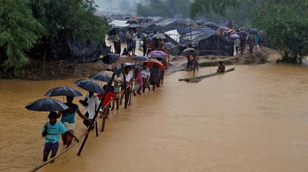 People cross a river from a Rohingya refugee camp in Cox’s Bazar, Bangladesh. Myanmar State Counselor Aung San Suu Kyi has told ANI that she intended to not use ‘emotive’ terms for an already affected population.(Reuters)