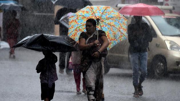 People brave the heavy rain at Kopar Khairne in Navi Mumbai on Tuesday(Bachchan Kumar/Hindustan Times)