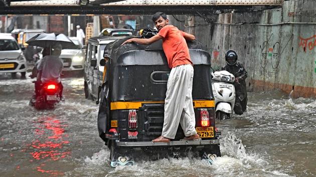 A man finds a creative way to avoid walking through the waterlogged Andheri subway. (Shashi S Kashyap/HT PHOTO)