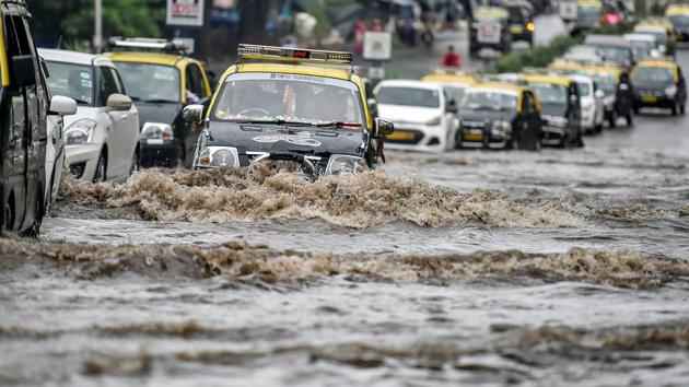 Cars pass trough a waterlogged street at Wadala. (Kunal Patil/HT PHOTO)