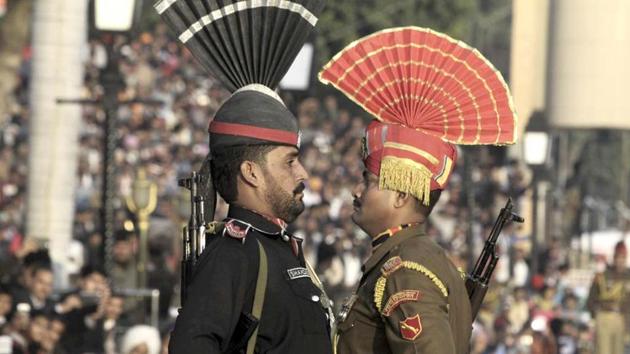 A Pakistani Ranger in black uniform and his Indian counterpart at the joint Pakistan-India border check post of Wagah near Lahore. AP photo(AP File)