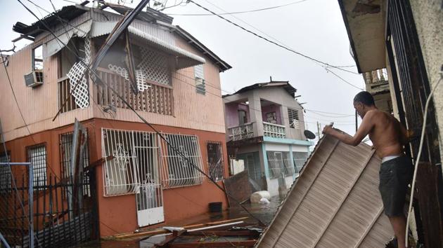 Residents of San Juan, Puerto Rico, deal with damages to their homes on September 20, 2017, as Hurricane Maria batters the island. Maria slammed into Puerto Rico on Wednesday, cutting power as terrified residents hunkered down in the face of the island's worst storm in living memory. After leaving a deadly trail of destruction on a string of smaller Caribbean islands, Maria made landfall on Puerto Rico's southeast coast around daybreak. (Hector Retamal / AFP) Residents of San Juan, Puerto Rico, deal with damages to their homes on September 20, 2017, as Hurricane Maria batters the island. Maria slammed into Puerto Rico on Wednesday, cutting power as terrified residents hunkered down in the face of the island's worst storm in living memory. After leaving a deadly trail of destruction on a string of smaller Caribbean islands, Maria made landfall on Puerto Rico's southeast coast around daybreak. (Hector Retamal / AFP)