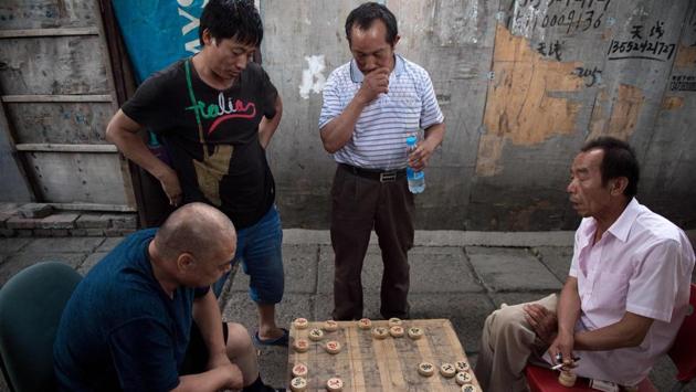 People play Chinese chess on a street in the migrant village on the outskirts of Beijing. China has hundreds of millions of migrants who have moved from the countryside to its towns and cities in recent decades to find work, their labour fuelling the country’s economic boom. (Nicolas Asfouri / AFP) People play Chinese chess on a street in the migrant village on the outskirts of Beijing. China has hundreds of millions of migrants who have moved from the countryside to its towns and cities in recent decades to find work, their labour fuelling the country’s economic boom. (Nicolas Asfouri / AFP)