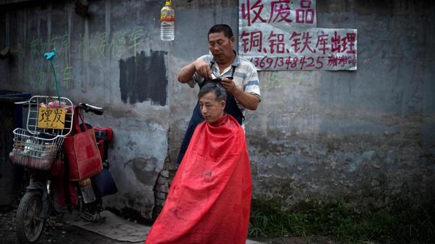A man gets a haircut on a street in Zhongguancun. ‘Some of us used to make 6,000 yuan a month as Didi (ride-share company) drivers. But the government said migrants can’t drive Didi, so we had to find other work,’ said Yang Qiang. (Nicolas Asfouri / AFP) A man gets a haircut on a street in Zhongguancun. ‘Some of us used to make 6,000 yuan a month as Didi (ride-share company) drivers. But the government said migrants can’t drive Didi, so we had to find other work,’ said Yang Qiang. (Nicolas Asfouri / AFP)