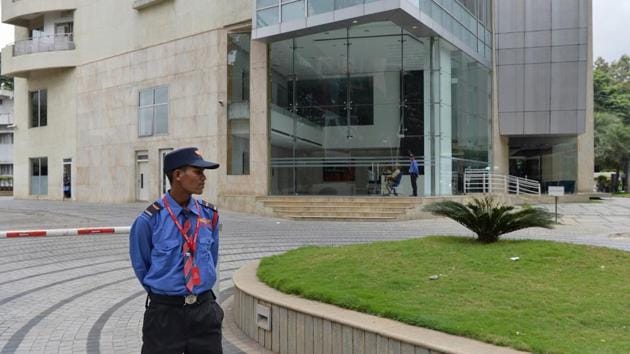 A private security personnel stands guard in front of Cafe Coffee Day Head Office building which was raided by the Income Tax Department in Bangalore on September 21, 2017.(AFP)