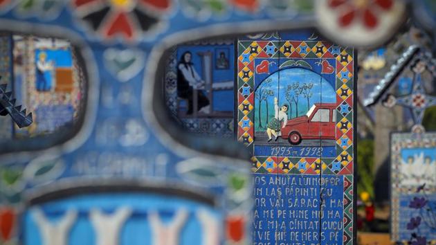 The story of a three-year-old child who was run over by a car is depicted on her cross in the Merry Cemetery. Another tells the tale of a 38-year-old man who had a ‘merciless death’ that snatched him from his wife and two daughters. (Vadim Ghirda / AP) The story of a three-year-old child who was run over by a car is depicted on her cross in the Merry Cemetery. Another tells the tale of a 38-year-old man who had a ‘merciless death’ that snatched him from his wife and two daughters. (Vadim Ghirda / AP)