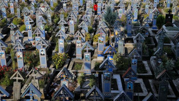 Some people consider the place less a graveyard and more an outdoor museum, looking at the cartoon-like drawings and limericks written in a quirky language used by locals and its rows of intricately carved blue, yellow, green and red crosses. (Vadim Ghirda / AP) Some people consider the place less a graveyard and more an outdoor museum, looking at the cartoon-like drawings and limericks written in a quirky language used by locals and its rows of intricately carved blue, yellow, green and red crosses. (Vadim Ghirda / AP)