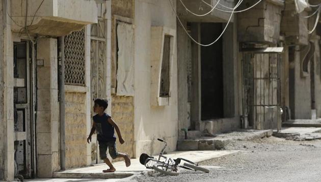 A Syrian boy runs near his bicycle in the eastern Syrian city of Deir Ezzor on September 21 as Syrian government forces continue to press forward with Russian air cover in the offensive against Islamic State group jihadists across the province.(AFP Photo)