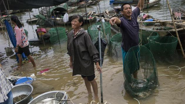 Lin Ziqiang, 43, and his wife, surnamed Chen, take their boat out to fish at sunrise every day, coming back to the shore next to a towering bridge at around 1 pm. Every evening, the couple sells their fresh catch at the market by the Beijiang River, making between 3,000 and 4,000 yuan (RS.29,879 and Rs.39,627 approx.) a month. (Fred Dufour / AFP)