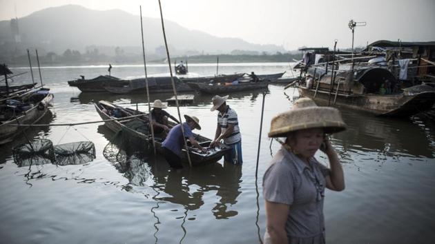 The community today is a collision of these two cultures -- the older fishers and the younger Tankas taking to land. (Fred Dufour / AFP)