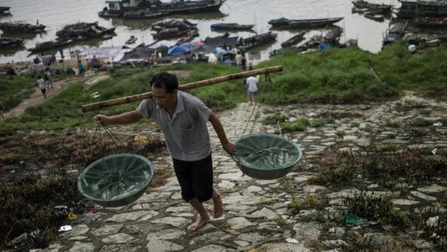 Some people from the Tanka community carry nets filled with fish to sell in the near by markets. The Tanka population in the southern Chinese coast used to be significant until the 1950s. As time passed, the local population shrinked. (Fred Dufour / AFP)