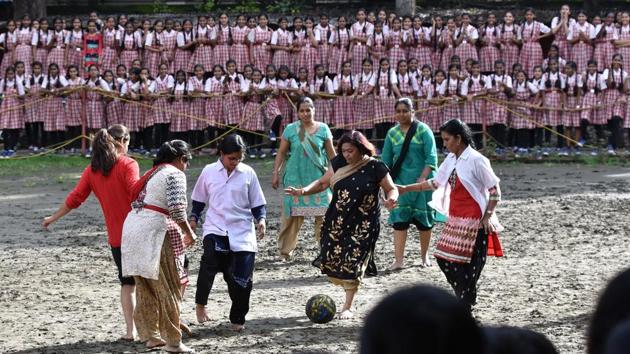 Women teachers and support staff of Renuka Swaroop Memorial Girls High School round up and  try to kick a football at the school ground in Pune. The game was played under initiative taken by government of Maharashtra, sports department and district sports council called 'Maharashtra Football Mission One Million' to promote football. (Pratham Gokhale/HT PHOTO) 