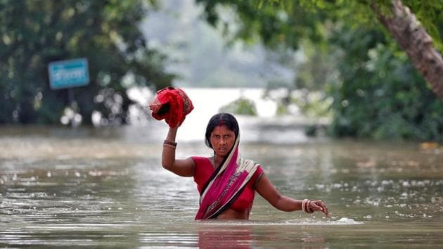 A woman wades through a flooded village in Bihar.(Reuters File Photo)