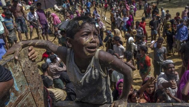 A Rohingya Muslim boy, who crossed over from Myanmar into Bangladesh, pleads with aid workers to give him a bag of rice near Balukhali refugee camp.(AP)