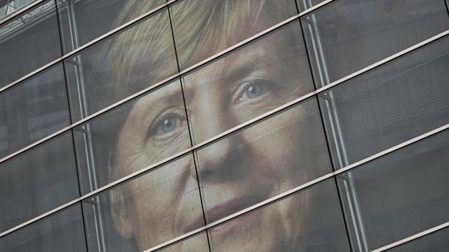 A picture of German Chancellor Angela Merkel can be seen behind the glass panes of the CDU headquarters in Berlin, Germany, on September 23, 2017, one day ahead of the German federal elections.(AP)