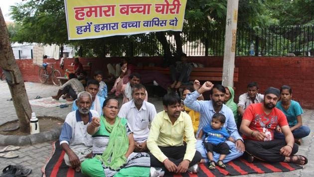 Family members of the newborn sitting on a dharna outside PGIMS on Saturday.(Manoj Dhaka/HT)