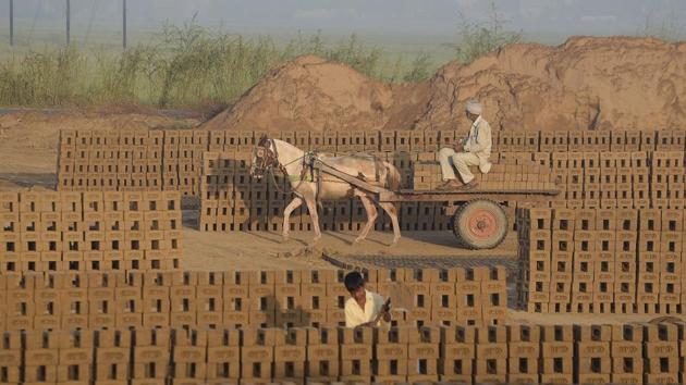 A labourer transporting bricks on a cart at a brick kiln on the outskirts of Jalandhar. Brick kiln workers in India are trapped in a cycle of bonded labour and regularly cheated out of promised wages, Anti-Slavery International said Wednesday, urging the government to safeguard their rights. A new report that surveyed kilns across the northern Punjab state details how rescued workers go back to the kilns again since no record is kept of payments and wages are withheld to lure them back. (SHAMMI MEHRA / AFP) A labourer transporting bricks on a cart at a brick kiln on the outskirts of Jalandhar. Brick kiln workers in India are trapped in a cycle of bonded labour and regularly cheated out of promised wages, Anti-Slavery International said Wednesday, urging the government to safeguard their rights. A new report that surveyed kilns across the northern Punjab state details how rescued workers go back to the kilns again since no record is kept of payments and wages are withheld to lure them back. (SHAMMI MEHRA / AFP)
