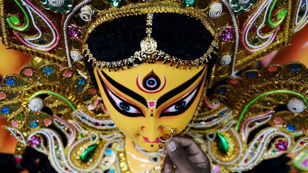 An artisan puts a nose ring as he gives finishing touches on a clay idol of the Hindu Goddess Durga at his workshop in Chennai. (ARUN SANKAR / AFP) An artisan puts a nose ring as he gives finishing touches on a clay idol of the Hindu Goddess Durga at his workshop in Chennai. (ARUN SANKAR / AFP)