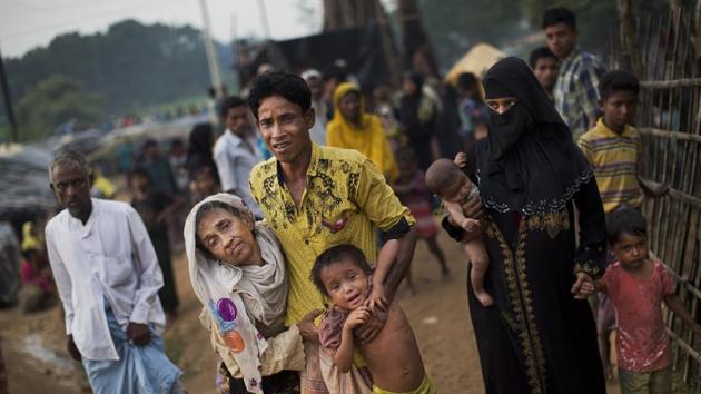 In this Sept. 5, 2017 file photo, an exhausted Rohingya helps an elderly family member and a child as they arrive at Kutupalong refugee camp after crossing from Myanmmar to the Bangladesh side of the border, in Ukhia.(AP File Photo)