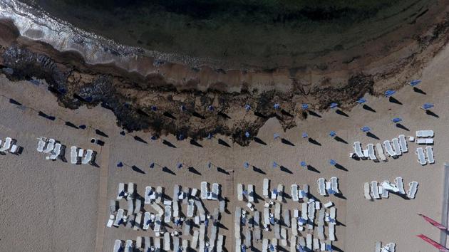Oil that leaked from a small oil tanker that sank on September 10, is seen next to sunbeds and folded umbrellas on the beach of Agios Kosmas at the riviera in Athens, Greece, September 17, 2017. (Giorgos Moutafis / REUTERS) Oil that leaked from a small oil tanker that sank on September 10, is seen next to sunbeds and folded umbrellas on the beach of Agios Kosmas at the riviera in Athens, Greece, September 17, 2017. (Giorgos Moutafis / REUTERS)