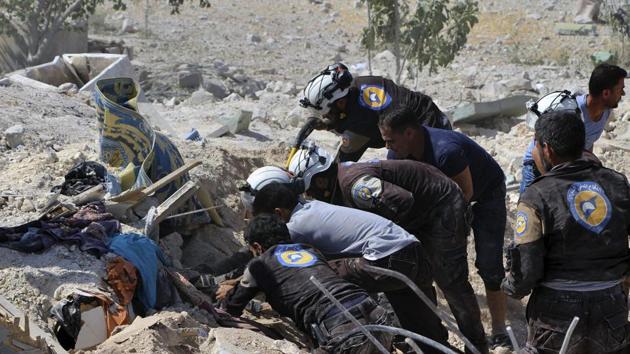 This photo provided by the Syrian Civil Defense White Helmets, shows civil defense workers searching through the rubble after airstrikes hit Khan Sheikhoun, in the northern province of Idlib, Syria, on Sunday. (AP) This photo provided by the Syrian Civil Defense White Helmets, shows civil defense workers searching through the rubble after airstrikes hit Khan Sheikhoun, in the northern province of Idlib, Syria, on Sunday. (AP)