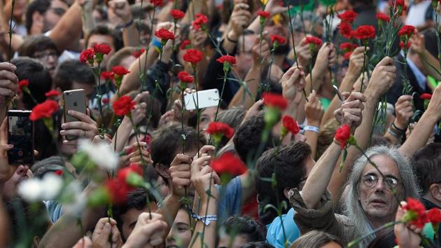 People hold flowers during a protest near the Economy headquarters of Catalonia's regional government in Barcelona on September 20, 2017. Thousands took to the streets of Barcelona as Spanish police detained 13 Catalan government officials in a crackdown ahead of an independence referendum which Madrid says is illegal. (Lluis Gene / AFP) People hold flowers during a protest near the Economy headquarters of Catalonia's regional government in Barcelona on September 20, 2017. Thousands took to the streets of Barcelona as Spanish police detained 13 Catalan government officials in a crackdown ahead of an independence referendum which Madrid says is illegal. (Lluis Gene / AFP)