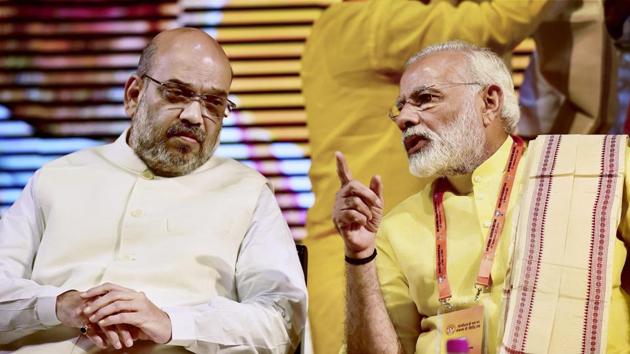 Prime Minister Narendra Modi speaks to BJP president Amit Shah during the party's national executive meeting at Talkatora Stadium, New Delhi, on Monday.(PTI photo)