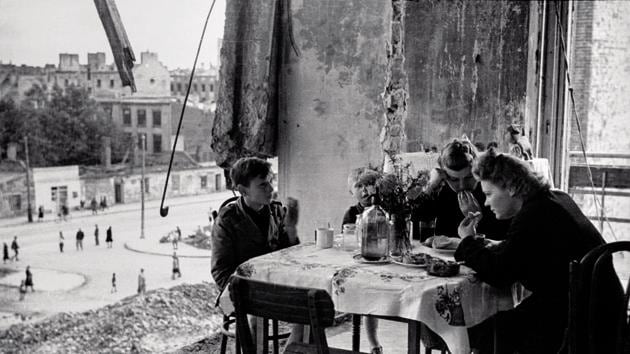Warsaw 1945. The everyday life of Warsaw people remained in ruins after the war — here a family is seen eating at their battered home.(PAP / Karol Szczeciński)