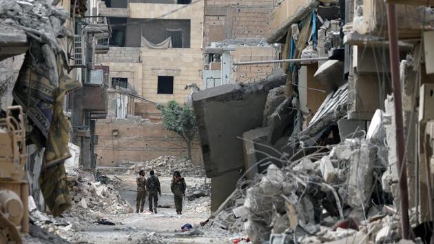 ‘We promised our friends who were martyred this victory,’ said Berkhdan, a young fighter wearing a green scarf with a floral pattern wrapped around his head. ‘We feel happy because we’re witnessing historic moments with the fall of Raqqa and the defeat of Daesh,’ he added. ‘The liberation of Raqqa will enter the history books.’ (Rodi Said / REUTERS) 