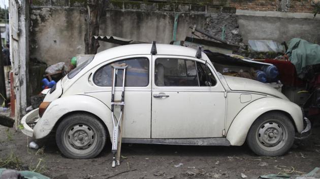 Rodarte leans his crutches against a white Volkswagen Beetle before he puts his heavily tattooed arms to work lifting and tossing bricks and twisted metal. Clad in a neon orange vest, a white construction helmet and dirty jeans, he keeps his balance by bracing the stump of his leg on pieces of debris. (Miguel Tovar / AP) Rodarte leans his crutches against a white Volkswagen Beetle before he puts his heavily tattooed arms to work lifting and tossing bricks and twisted metal. Clad in a neon orange vest, a white construction helmet and dirty jeans, he keeps his balance by bracing the stump of his leg on pieces of debris. (Miguel Tovar / AP)