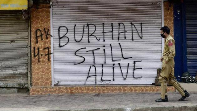 Srinagar: A policeman walks out side closed shops during restriction and strike in Srinagar. Authorities had imposed restrictions in most parts of Valley following the killing of Burhan Wani(PTI)